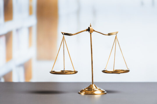 Shiny golden balanced scale in court library background as concept justice and fairness legal symbol. Scale balance for righteous and equality judgment by lawyer and attorney. equility