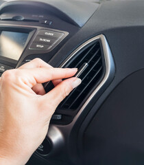 Woman's hand adjusting  air conditioning  in car