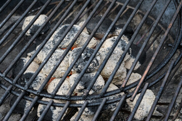Rozpalony grill ogrodowy z brykietem pokrytym białym popiolem gotowy do pieczenia potrawy  - obrazy, fototapety, plakaty