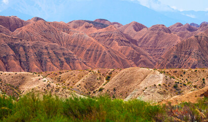 Natural unusual landscape of red rocks against the backdrop of blue mountains. The extraordinary beauty of nature is similar to the Martian landscape. Amazingly beautiful landscape.