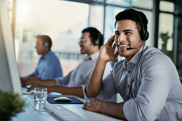 Callcenter agent, smile and man in office consulting with advice, help and happiness at desk. Happy...