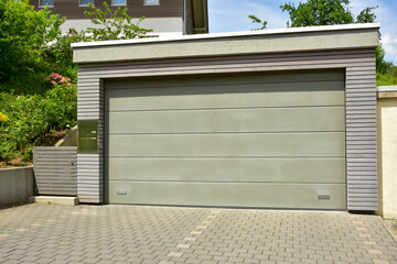 Moderne Beton-Garage mit Automatik-Tor in der Hauszufahrt
