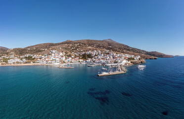 Andros island Batsi Cyclades Greece. Aerial drone view of port boat, building, sandy beach sea sky.