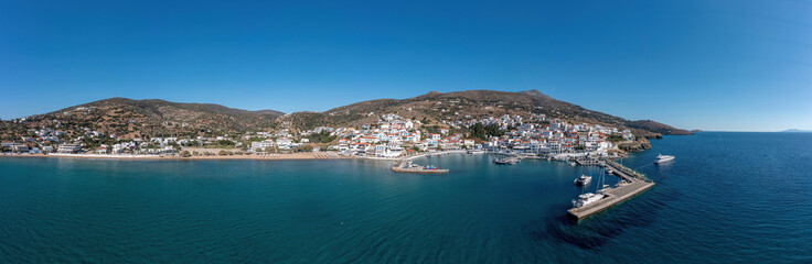 Fototapeta na wymiar Andros island, panorama of Batsi village, Cyclades Greece. View from ship of port, sea, sky. Banner