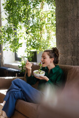 Young woman eating salad in an office.