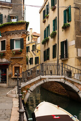 Fototapeta na wymiar Narrow canals of Venice city with old traditional architecture, bridges and boats, Veneto, Italy. Tourism concept. Architecture and landmark of Venice. Cozy cityscape of Venice.