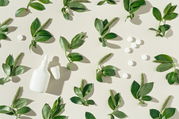 Seasonal spring allergies, fresh spring blooming branches tree with green new leaves, white nasal spray bottle, pills on beige background, top view trend flat lay pattern, Allergy treatment