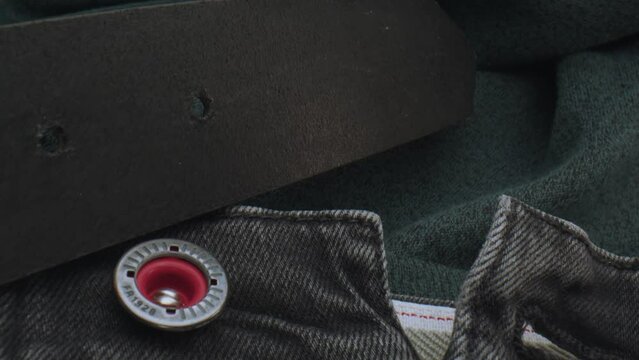 A Pari of Jeans, a Leather Belt and Metal Button, Undone, Camera Tracks Over Jeans, No People