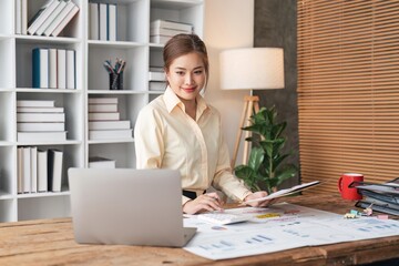 Businesswoman sits at work with laptop and computer and analyzes corporate and tax activities at office