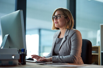 Computer, typing and business woman in office working late on project at night alone. Desktop, professional and female person writing email, report or planning, reading and overtime for deadline.