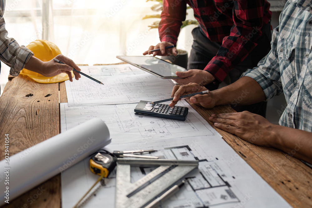 Poster team engineer checks construction blueprints on new project with engineering tools at desk in office