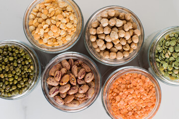Legumes in glass jars top view. Vegetable protein, vegetarianism, healthy eating