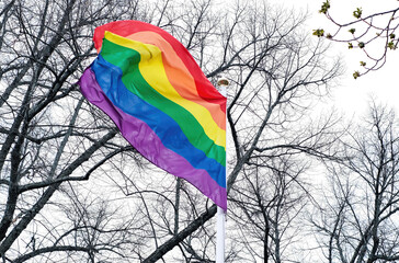 Close-up LGBT pride flag against a vibrant sky, evoking a sense of openness and freedom