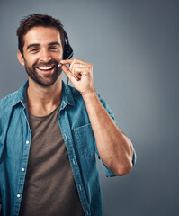 Happy man, call center and headphones of consultant on mockup against a grey studio background....