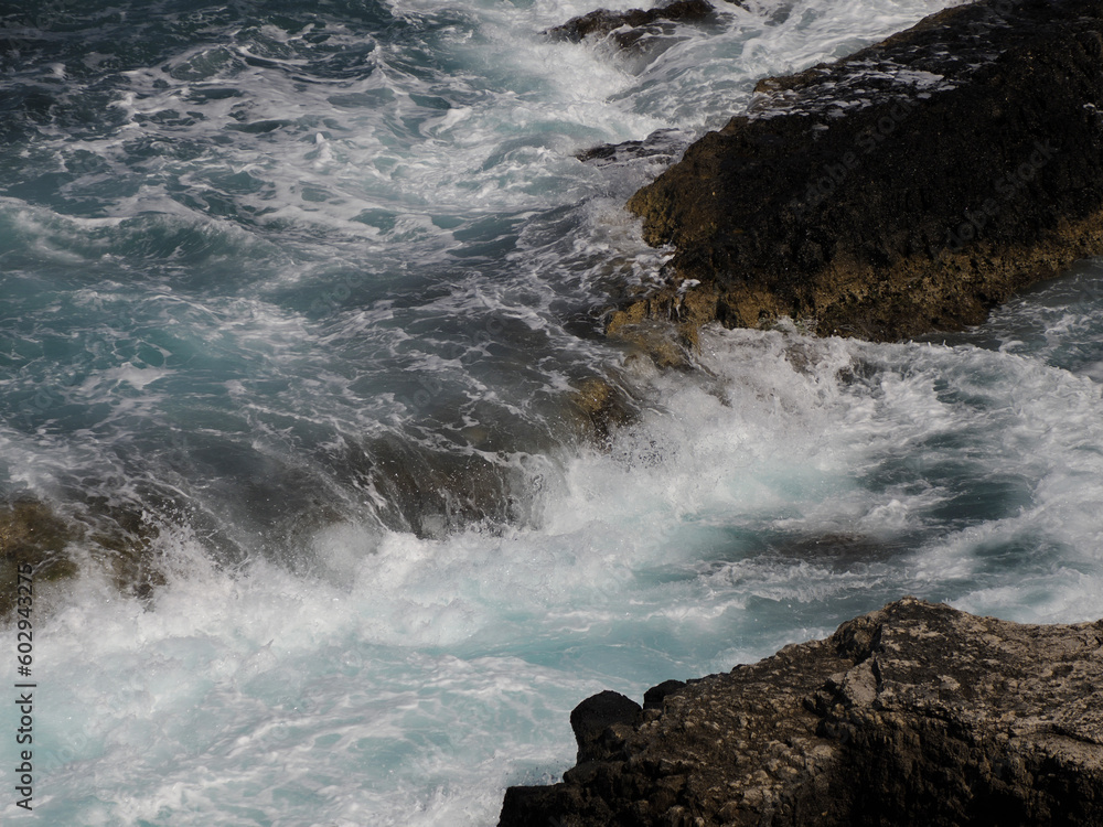 Wall mural sea waves splashing on lava rocks