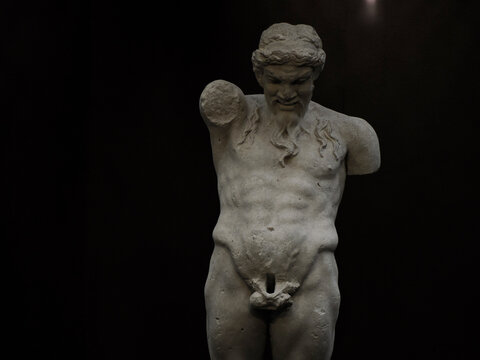 Ancient statue of Priapus symbol of the fertility of ancient Rome isolated on blACk