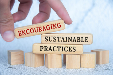 Encouraging sustainable practices text on wooden blocks. Conservation and nature concept