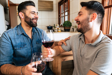 happy gay couple drinking wine and talking at home