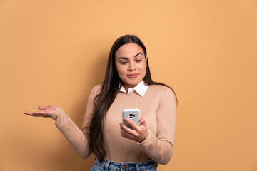 puzzled young woman with sad face expression in beige colors. app, social media, connection concept.