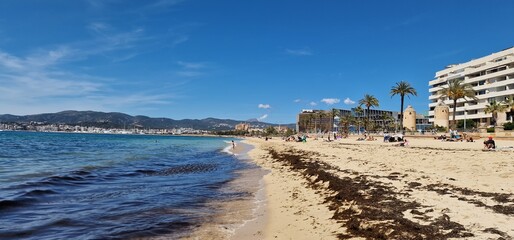 The beach in Palma de Mallorca is a sun-soaked paradise, where golden sands stretch along the crystal-clear waters of the Mediterranean Sea. This idyllic coastal escape is characterized by its invitin