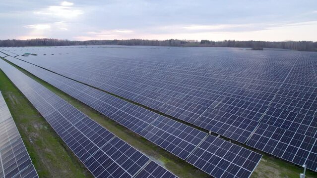 Aerial over big solar farm in Europe with neat rows of PV panels