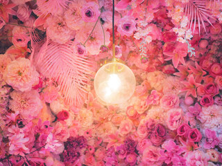 light bulb over pink rose and carnation flowers bouquet background.