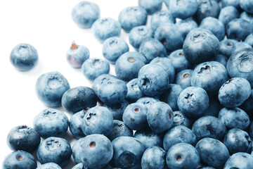 Fresh blueberries scattered on a white background.