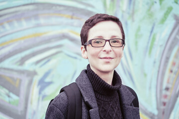 Portrait of woman in glasses with short haircut. Androgynous appearance, non-binary personality.