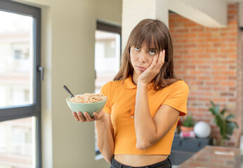 young pretty woman feeling bored, frustrated and sleepy after a tiresome. breakfast bowl concept