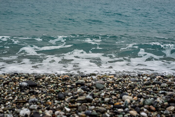 oceano de agua salada con olas, piedras y arena