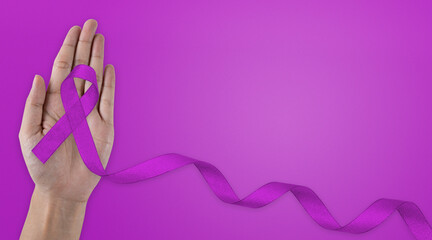 Healthcare, insurance concept. Hands holding purple or violet ribbon on white fabric with copy...