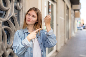 pretty young woman looking impatient and angry, pointing at watch, asking for punctuality, wants to...