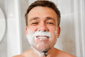 A man shaves his face with a safety razor. The concept of men's cosmetics and shaving accessories....