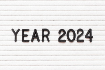 Black color letter in word year 2024 on white felt board background