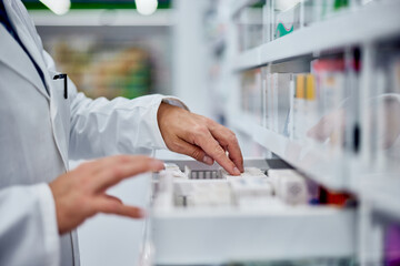 Side view of a male hands, searching for something from the drawer, working as a pharmacist.