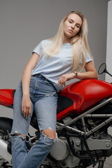 Fototapeta na wymiar Shot of dressed in casual clothing woman motorcyclist and her powerful motorbike.