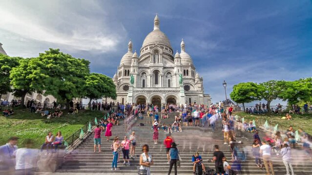 Tourists near the Basilica of the Sacred Heart of Paris (Sacra-Coeur) is a Roman Catholic church timelapse hyperlapse. Located at the summit of the butte Montmartre. Front view. Paris, France.