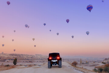 Back view ATV quad bike with set colorful hot air balloon in Cappadocia Goreme Turkey, copy space © Parilov