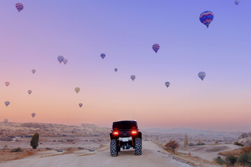 Back view ATV quad bike with set colorful hot air balloon in Cappadocia Goreme Turkey, copy space