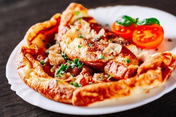 omelette with bacon in a white plate on wooden table