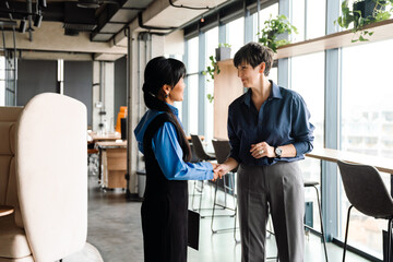Professional pretty multinational colleagues finished business meeting and shaking hands in office