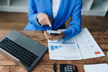 Busy businesswoman wearing a suit busy with work workaholic while sitting at work clear paperworks...