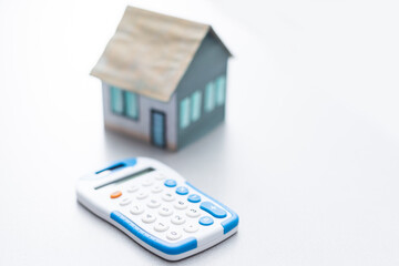Real Estate Concept - Miniature Model House with Calculator