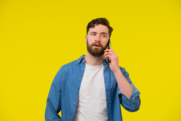 Young smiling happy cheerful caucasian man 20s wear white casual shirt talk speak on mobile cell...
