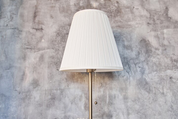 White floor lamp on the background of a concrete wall, ideal for reading in the living room. It is...