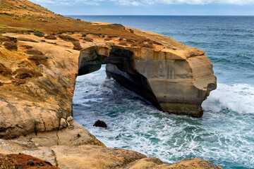 rock arch formed by the sea at Tunnel Beach, Dunedin, New Zealand