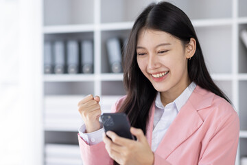Obraz na płótnie Canvas Excited Asian woman sit at desk feel euphoric win online lottery, happy black woman overjoyed get mail at tablet being promoted at work, biracial girl amazed read good news at computer 
