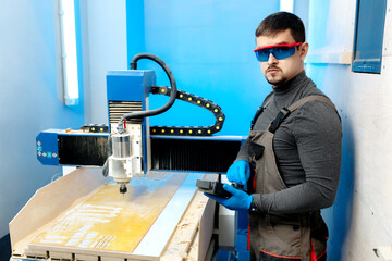 Engineer or technician operating with CNC milling machine in lab. Aircraft capable of GPS...