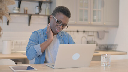 Young African Man with Neck Pain Working on Laptop