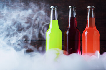 Citrus summer cold drinks in glass bottle, smoke background